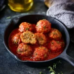 Polpette di lenticchie al sugo servite su un piatto decorativo.