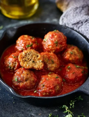 Polpette di lenticchie al sugo servite su un piatto decorativo.