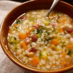 Piatti di minestrone d'orzo con verdure fresche in un pentolone