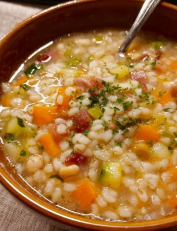 Piatti di minestrone d'orzo con verdure fresche in un pentolone