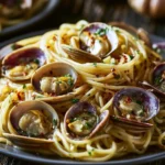 Piatto di spaghetti alle vongole con pomodorini e prezzemolo fresco