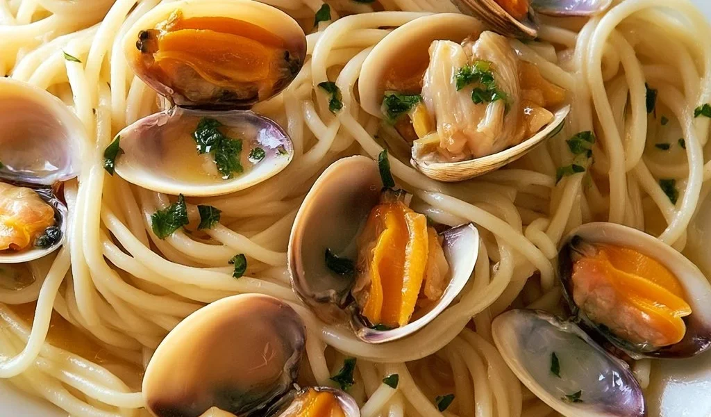 Tagliatelle con vongole, cannolicchi e fasolari in un piatto fresco di mare