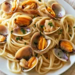Tagliatelle con vongole, cannolicchi e fasolari in un piatto fresco di mare