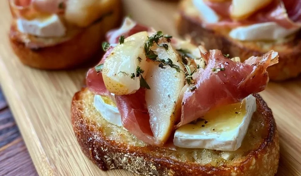Crostini con Brie, Pere e Prosciutto Crudo serviti su un piatto elegante