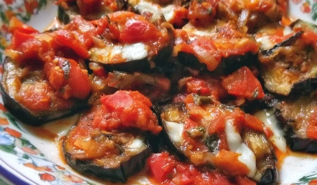 Melanzane alla pizzaiola, un piatto italiano saporito con pomodoro e spezie.