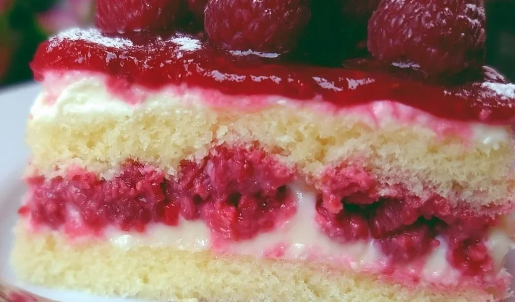 Fetta di Torta Paradiso ai Lamponi su piatto bianco