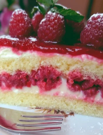 Fetta di Torta Paradiso ai Lamponi su piatto bianco