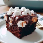 Torta poke di cioccolato e marshmallow decorata con topping colorati.