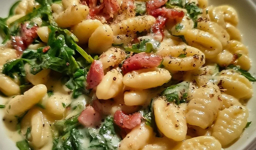 Cavatelli con speck, crema di patate e rucola, un piatto tradizionale italiano