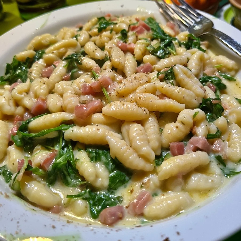 Cavatelli con speck, rucola e crema di patate, piatto gustoso e appetitoso.