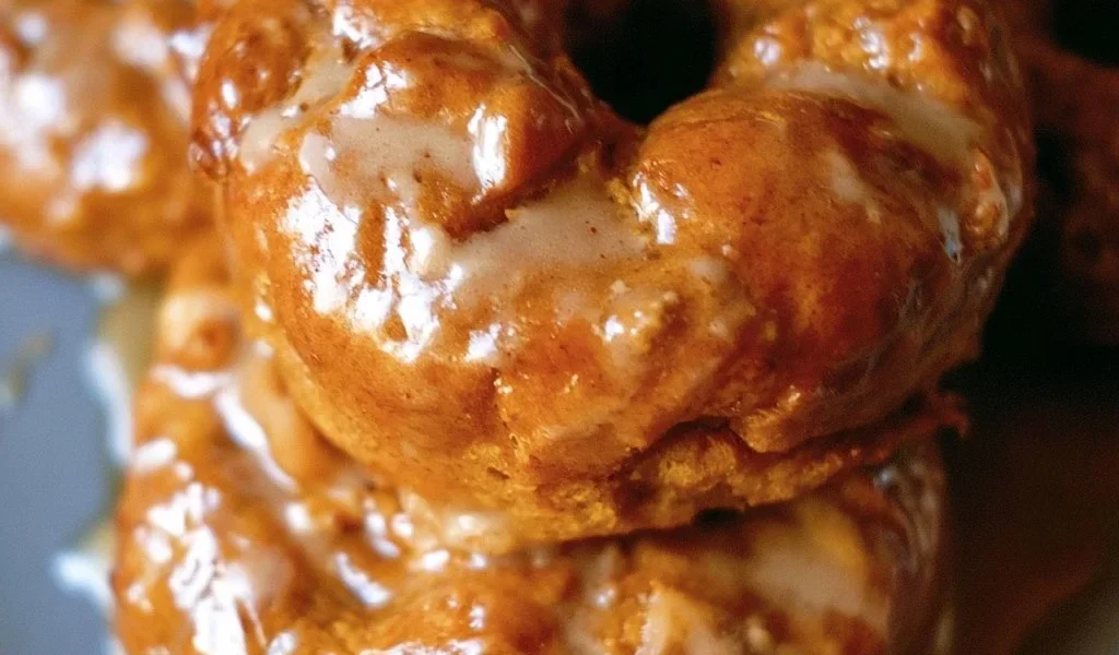Ciambelle di zucca al forno con glassa d'acero su un piatto bianco