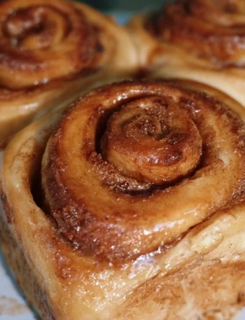Freshly baked cinnamon buns with sweet icing and cinnamon swirl