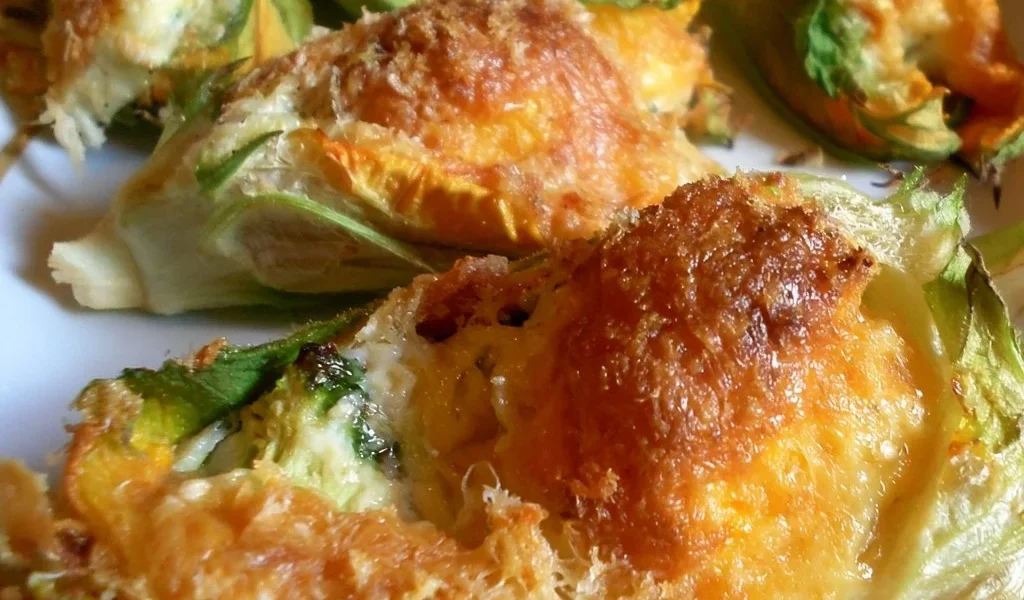 Fiori di zucca ripieni gratinati serviti su un piatto elegante