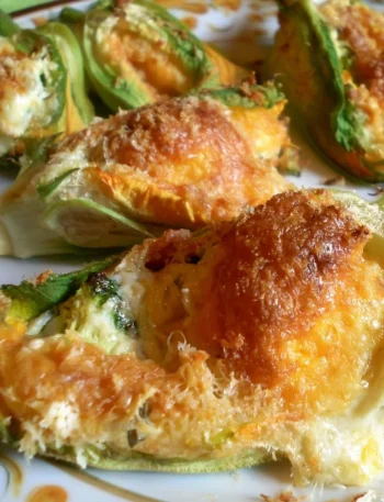 Fiori di zucca ripieni gratinati serviti su un piatto elegante