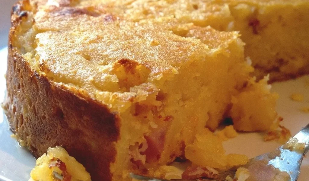 Gâteau di patate servito su un piatto bianco con contorni colorati