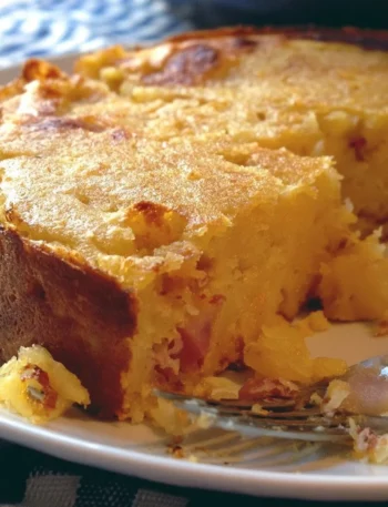 Gâteau di patate servito su un piatto bianco con contorni colorati