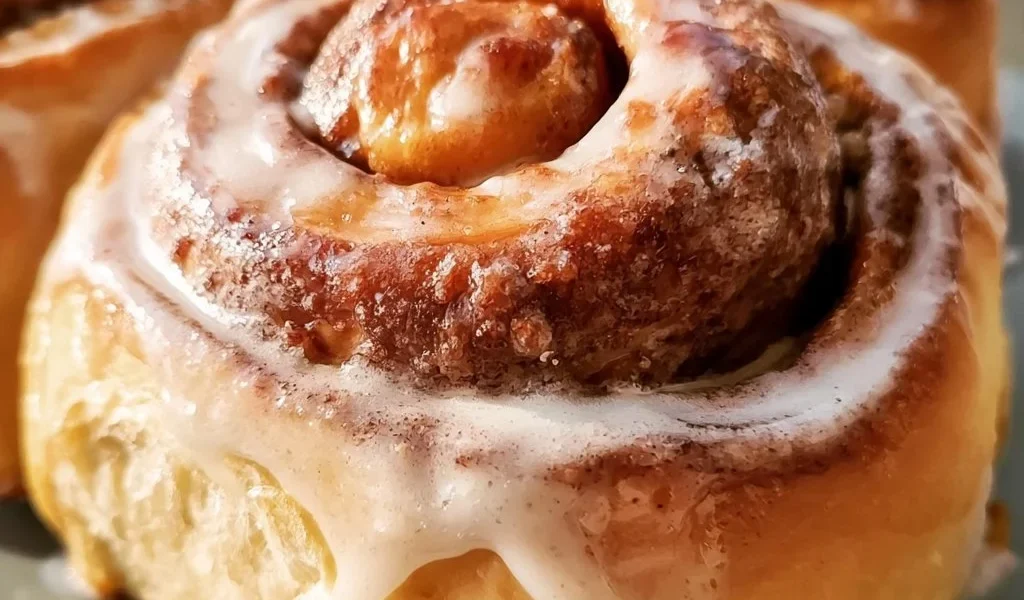 Un delizioso cinnamon bun appena sfornato con glassa