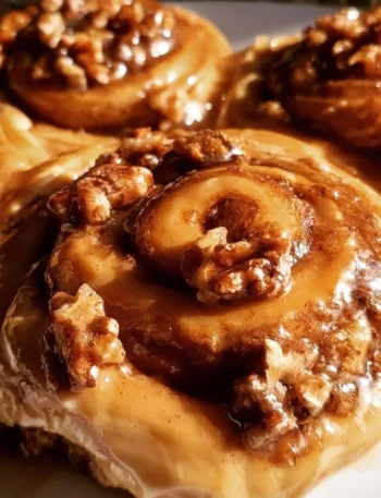 Delicious Maple Pecan Cinnamon Rolls topped with icing and pecans