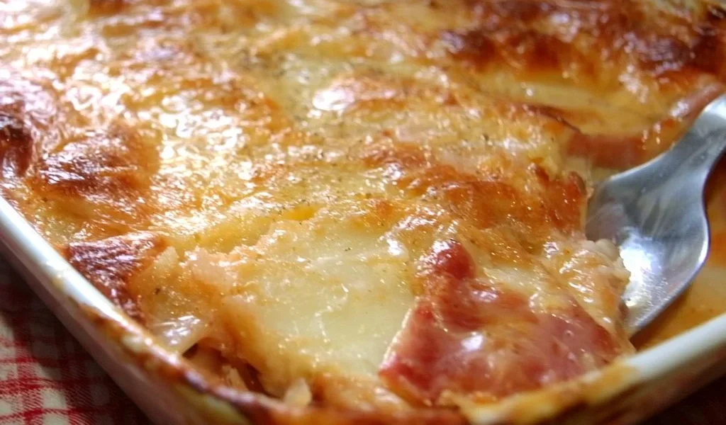 Piatto di Parmigiana di Patate e Prosciutto Cotto appena sfornato