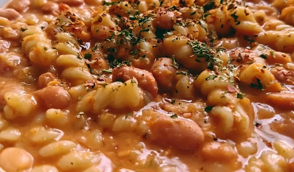 Pasta ai Fagioli servita in una ciotola con fagioli e condimenti.