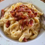 Pasta con Crema di Patate e Pancetta servita in un piatto elegante