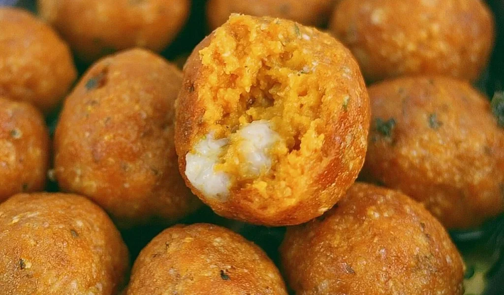 Piatto di polpette di zucca appena sfornate, pronte da servire.