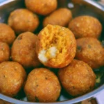 Piatto di polpette di zucca appena sfornate, pronte da servire.