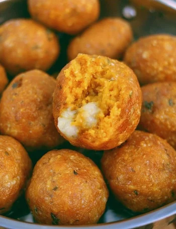 Piatto di polpette di zucca appena sfornate, pronte da servire.
