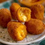 Plate of pumpkin croquettes with a melting heart, garnished and ready to serve.