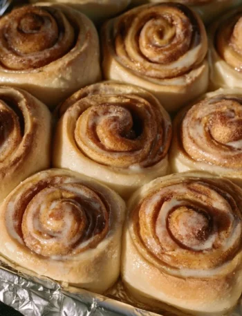 Pane e rotoli alla cannella appena sfornati in una teglia dorata