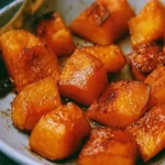 Bowl of roasted pumpkin garnished with herbs and spices