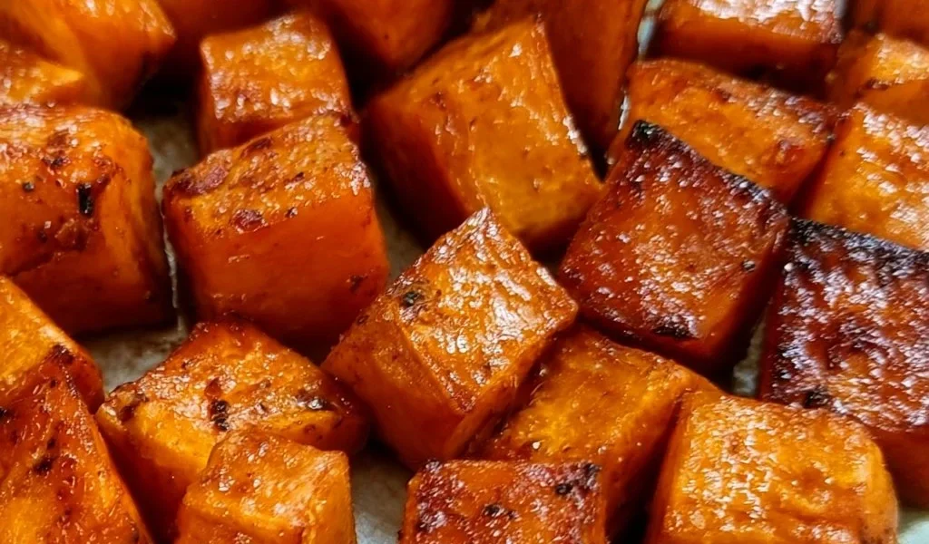 Plate of roasted sweet potatoes seasoned and garnished