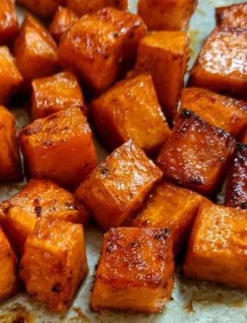Plate of roasted sweet potatoes seasoned and garnished