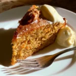 Fetta di torta di carote con glassa, decorata con noci e carote grattugiate
