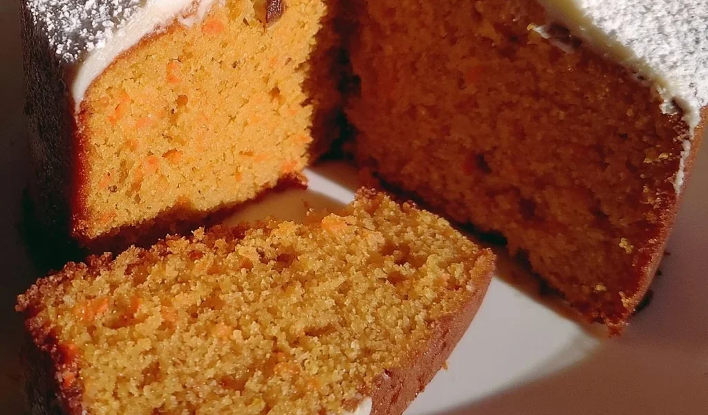 Fetta di torta di carote fresca e decorata con noci.