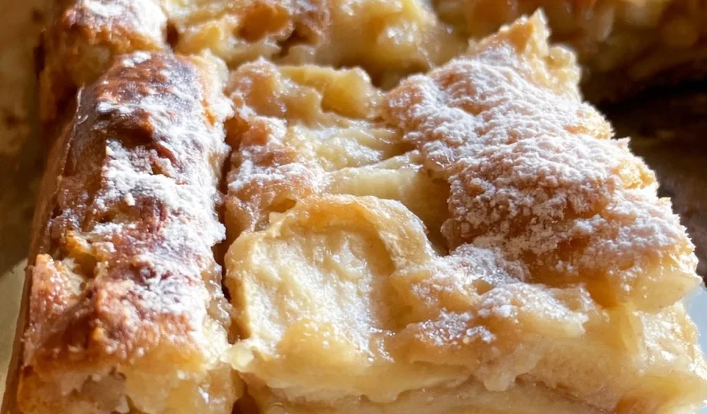Fetta di Torta di Mele appena sfornata con mele fresche e cannella.