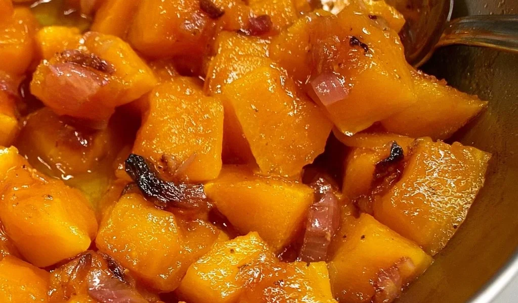 Zucca in padella in agrodolce servita in un piatto elegante.