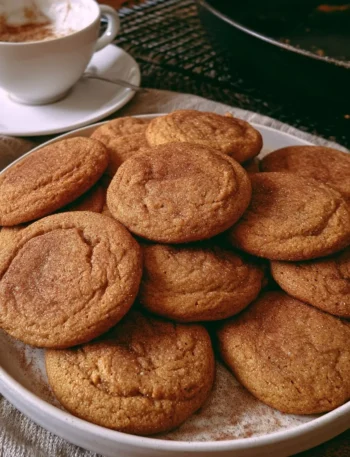 Biscotti morbidi alla zucca e cannella serviti su un piatto in legno