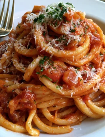 Piatto di Bucatini all'amatriciana servito con guanciale e pomodoro