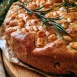 Castagnaccio toscano con pinoli e rosmarino su un piatto rustico