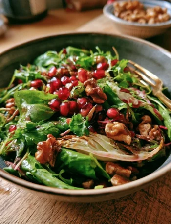 Insalata autunnale con melagrana, finocchi e noci in un piatto colorato e gustoso