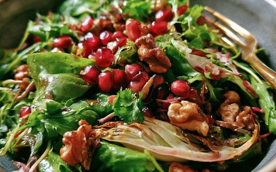 Insalata autunnale con melagrana, finocchi e noci in un piatto colorato e gustoso