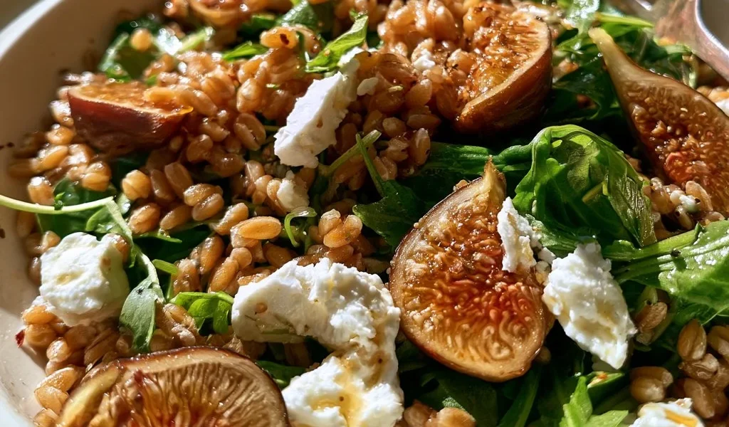 Insalata di farro con fichi, rucola e feta servita in un piatto elegante.