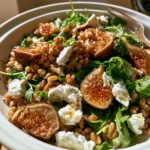Insalata di farro con fichi, rucola e feta servita in un piatto elegante.