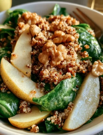 Insalata di quinoa con pere, spinaci e noci in un piatto colorato e salutare