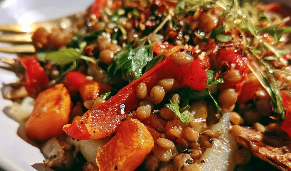 Insalata tiepida di lenticchie e verdure arrosto, piatto sano e colorato.