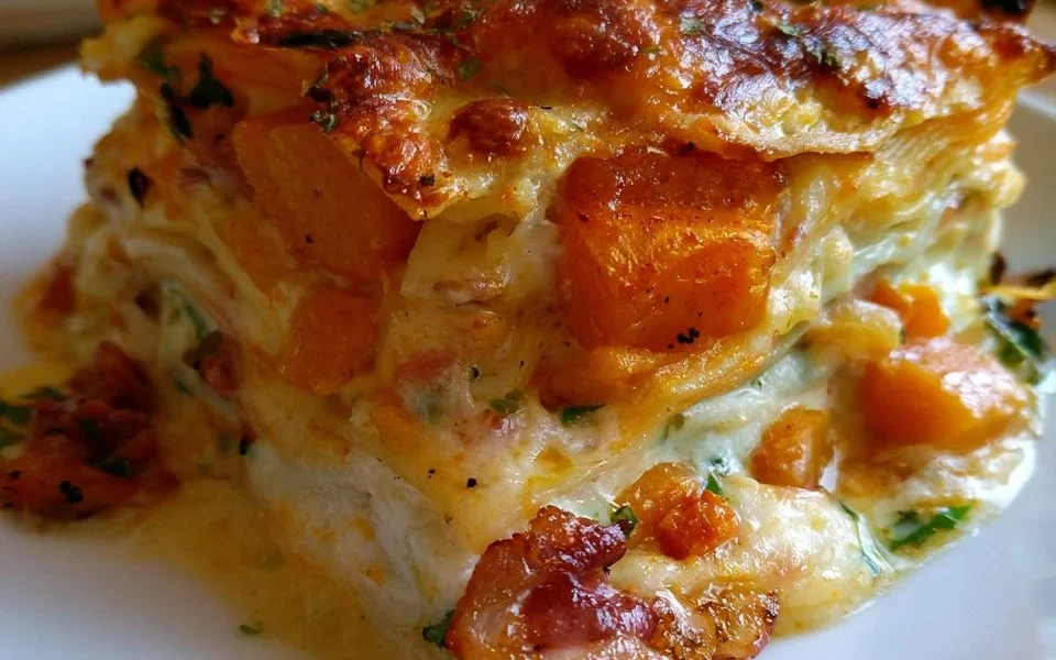 Lasagne alla zucca con speck e scamorza servite in un piatto