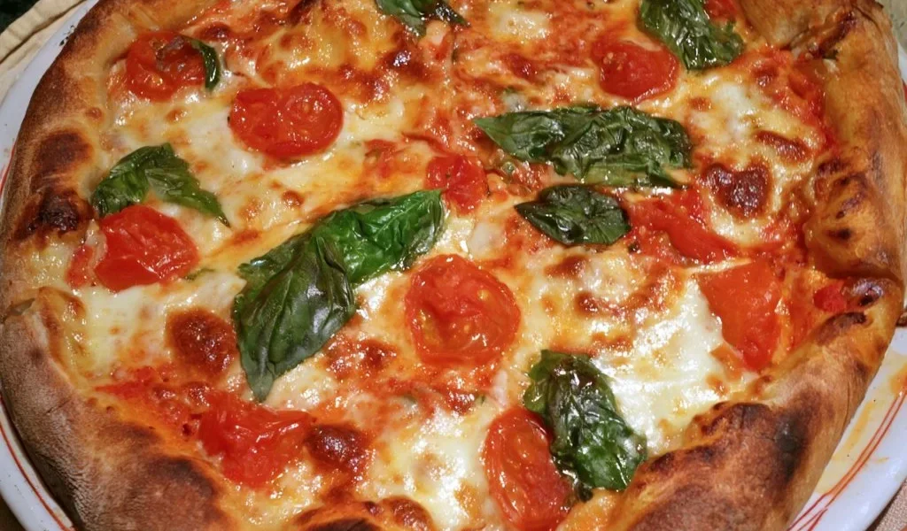 Pizza Margherita fatta in casa con pomodoro, mozzarella e basilico fresco
