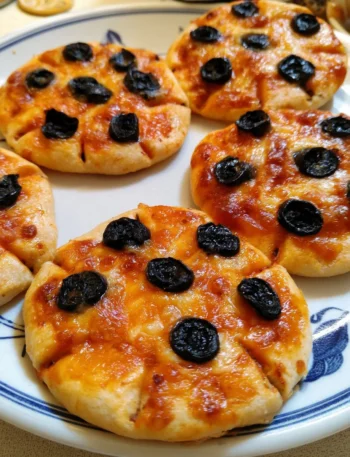 Pizzette ragno con olive nere, un finger food italiano appetitoso