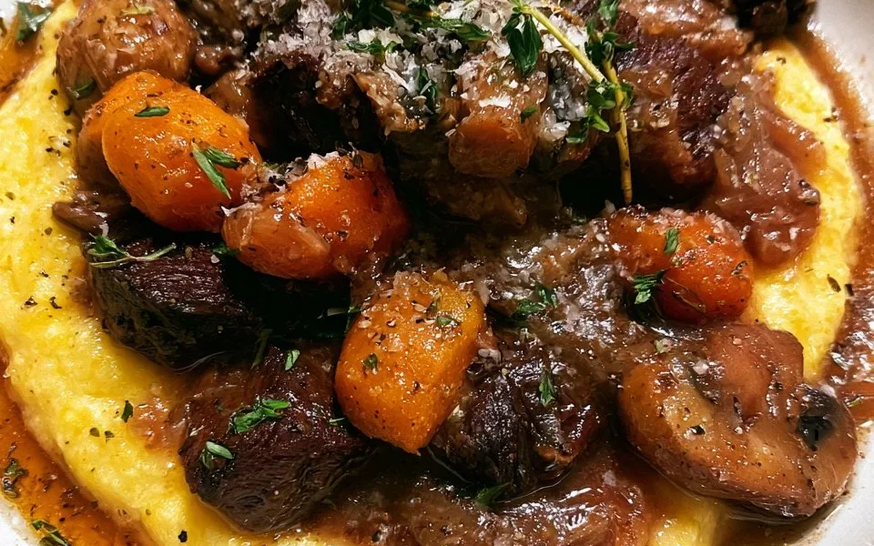 Piatto di polenta con spezzatino di manzo e funghi, ricetta tradizionale